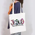 Casual white canvas tote bag featuring a colorful JESUS print, shown carried over the shoulder. - JESUS Colorful Style (11)