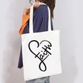 Detailed view of a stylish white canvas tote bag featuring a black artistic Faith heart print - Faith Heart Style (5)