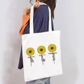 Lifestyle shot of a woman carrying a white canvas tote bag with sunflower faith Jesus print. - Faith Jesus Sunflower Style (3)