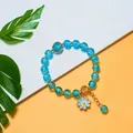 Handmade blue crackle glass beaded bracelet featuring a delicate flower charm and gold spacer beads - S292