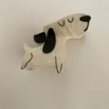 Detailopname van een schattige crèmewitte hondenhaarklem van acetaat met zwarte accenten. - 2# Beige hond met lang gezicht Stijl