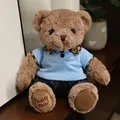 Simpatico orsetto di peluche marrone con polo blu e pantaloni scuri a righe - Orso Cammello in Abiti Blu / 20-30cm