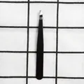 Detail view of professional matte black slant tip eyebrow tweezers on checkered background - 1.0mm Slanted Tip / Black