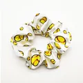 Detailed view of white satin scrunchie with vibrant yellow baseball pattern print - White Stitched Baseball