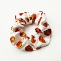 Detailed view of a white satin hair scrunchie with vibrant orange basketball patterns - White Base Basketball