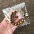 Hand holding a transparent PVC self-sealing jewelry storage bag with wooden bracelet inside - 11*11-26 Microns No Holes [100 Pieces] - Limited-time Price Reduction
