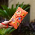 Ethnic style embroidered floral canvas long wallet clutch in a vibrant orange finish - Orange