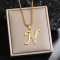 Collier plaqué or élégant avec pendentif lettre N en strass sur boîte de bijoux. - Chaîne Plaquée Or