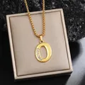 Élégant collier pendentif lettre O plaqué or avec strass étincelants sur un écrin. - Chaîne Plaquée Or