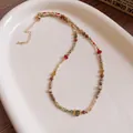 Ethnic bohemian style necklace featuring colorful crystal beads and golden extension chain - Colorful