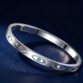 Sleek stainless steel bangle featuring colorful gemstones and evil eye motifs - Silver