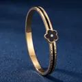 Bracelet jonc élégant en acier doré avec motif fleur en émail noir et cristal central - Largeur 6mm / Or/Noir