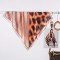 Dettaglio di un elegante foulard in seta con stampa leopardata e motivi a righe arancio - Patchwork leopardato caramello / 70x70cm