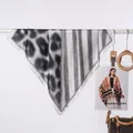 Primo piano di un elegante foulard da donna con stampa leopardata e a righe appeso a un'asta - Patchwork leopardato nero / 70x70cm