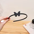 Matte black plastic headband featuring a stylish butterfly design for daily wear. - Butterfly Style / Black