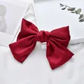 Close-up of a vibrant red satin oversized bow hair clip on a white background - Wine Red Duckbill Clip