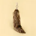 Macro detail of a fluffy fox tail keychain with a silver metal hook and ring clasp - Khaki