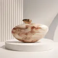 Close-up of elegant acrylic evening clutch with marble pattern and gold metallic clasp - Caramel color