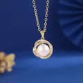 Detail van een gouden ketting met ronde witte parel en kristallen halo effect. - Goud (XL85009-J-03076)