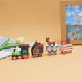 Detailed view of 4-piece wooden Christmas train ornament on decorative desk setup. - 1898 Dark Green