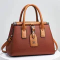 Brown lychee pattern handbag with top handles and adjustable strap on a display stand - 28x14x20cm / Khaki/Earth Yellow