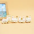 Vue détaillée d'un petit train de Noël en bois blanc et doré avec des figurines - Blanc