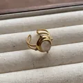 Macro detail of a vintage gold-tone ring featuring an oval translucent gemstone inlay. - Double-row Hollow Oval Yellow Gemstone Style (JZ0372) / Adjustable Open Ring (2cm) / Yellow