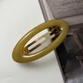 Dettaglio di un fermaglio per capelli ovale in acrilico verde oliva con chiusura oro - Verde militare (10CM)