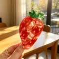 Detailed view of a red acetate strawberry hair claw clip with golden glitter accents - Large Strawberry