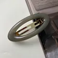 Dettaglio di un fermaglio per capelli ovale in acrilico grigio con molla dorata - Grigio (10CM)