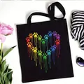 Stylish black canvas tote bag featuring a colorful rainbow dripping paw print heart design - Rainbow Paw Heart Style (No. 2) / 35x40cm