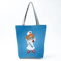 Detail shot of a blue tote bag featuring a cute cartoon nurse print with gray handles. - Bright Blue Cartoon Nurse Illustration Style (hl1548)