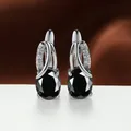 Elegant silver-tone hoop earrings featuring oval black gems and small crystal accents. - Platinum Plated Black Zirconia