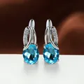 Elegant silver-colored stud earrings featuring oval water blue crystals and accents. - Platinum Plated Aqua Blue