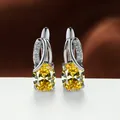 Elegant silver stud earrings with oval yellow gemstones and clear crystal accents - White Gold With Yellow Zircon