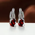 Elegant silver earrings featuring oval red zircon stones with diamond accents - Platinum Plated Red Zirconia