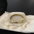Elegante weiße Clutch mit glänzendem goldfarbenem Metallgriff und Kette für Abendpartys - Cremeweiß