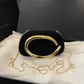 Elegante schwarze Samt-Clutch mit goldenem C-Griff und Kettenschultergurt im Vintage-Stil - Schwarz