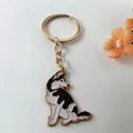 Close-up view of a golden metal keychain with a cute sitting husky dog enamel charm - Husky Style 2