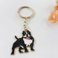 Close-up of a black and white pitbull enamel dog keychain with a gold-toned metal ring. - Bully Dog Style