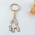 Close-up of cute dog-shaped enamel keychain with gold metal finish and white coating - Beagle Style