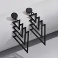 Primo piano di orecchini geometrici neri con design a triangoli sovrapposti ed eleganti - Stile a triangolo geometrico multistrato / Nero