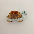 Detailed view of turtle-shaped hair claw clip made of tortoiseshell acetate material - Turtle