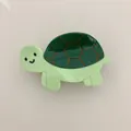 Detailed macro shot of a cute green turtle shaped acetate hair claw clip for women - Green Turtle