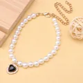 Close-up of elegant pet pearl necklace featuring a black heart-shaped rhinestone pendant. - Black
