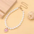 Dettaglio di una graziosa collana di perle per animali con pendente a cuore in cristallo rosa - Rosa