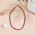 Non-tarnish titanium steel necklace with brown goldstone beads in a flat lay setup - Gold Sandstone Necklace