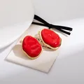 Orecchini a perno geometrici rossi in smalto con bordo dorato su sfondo minimalista - Orecchino a Clip Geometrico Rosso