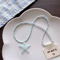 Close-up detail of a blue beaded summer necklace with a glittery starfish pendant - No.2 Light Blue Starfish