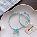 Detail view of summer blue beaded necklace featuring a translucent mermaid tail pendant - No.3 Fish Tail